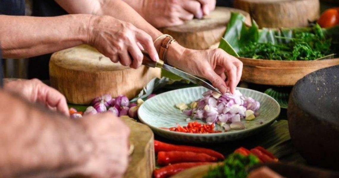 Hands chopping onions and chilli peppers for a Zanzibari cooking class