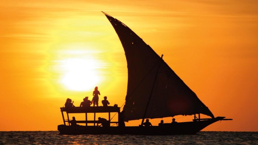 Traditional dhow sailing at sunset off Zanzibar